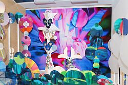 Raumwunder von Sigrid und Roland Schäfer mit dem Titel „Im Theater geht es rund – spielen muss man selber“. In einem Kasten sieht man viele verschiedene bunte Formen aus Papier.