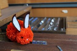 Osterhase aus Wolle neben alten Druckbuchstaben aus der Buchpresse