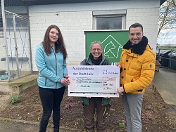 Katja Spirgatis vom Lahrer Tierheim steht zwischen den Auszubildenden Linda Bottner und Oskar Sütterlin und hält einen großen Scheck über 300 Euro.