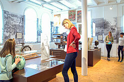 Eine Besucherin des Stadtmuseums sieht sich ein Exponat an.