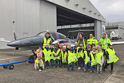 Gruppenbilder der Kinder der Kita Bottenbrunnenstraße mit ihrer Erzieherin und Mitarbeitenden des Lahrer Flughafens vor einem Flugzeug