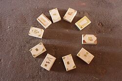 Römische Schatzkisten aus Holz mit Messingbeschlägen liegen in einem Kreis angereiht beieinander. Jede Schatzkiste ist individuell gestaltet.