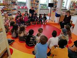 Die Kinder lauschen Karin Schmidt bei der Vorstellung eines Buches.