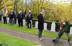 Beim Remembrance Day steht Oberbürgermeister Markus Ibert vor dem kanadischen Ehrenmal auf dem bergfriedhof und gedenkt den Gefallenen. Im Hintergrund Fahnenträger.