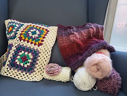 Das Bild zeigt Wollknäul sowie Gehäkeltes und Gestricktes