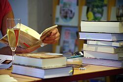 Jemand liest Buch mit einem Glas Sekt