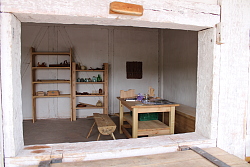 Das Foto zeigt selbst gebaute Regale, einen Tisch, eine Bank und eine Truhe