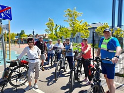 Auf dem Foto sieht man die Teilnehmenden mit ihrem E-Bike und Fahrradhelm auf dem Verkehrsübungsplatz im Mauerfeld. Instruktor Bernd Vieser (rechts) leitete das Sicherheitstraining im Auftrag des Stadtseniorenbeirats und des Treffpunkt Stadtmühle.