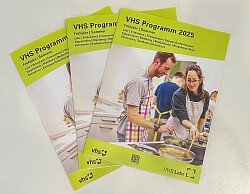 Das Bild zeigt fächerartig das Programmheft in dreifacher Ausfertigung