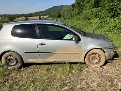 Großaufnahme eines Schrottfahrzeugs auf einer Wiese