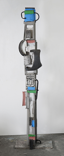 Das Foto zeigt die Skulptur Große Eimerfiguren bestehend aus Eimern, Metallklötzen, Klammern, Beton und halbe Dosenringe.