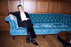 Wladimir Kaminer sitzt auf einem blauen Sofa