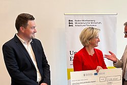 Lahrs Oberbürgermeister Markus Ibert und Gründungsmanager Tobias Fischer erhalten einen symbolischen Scheck aus Händen der Ministerin Hoffmeister-Krautt. 
