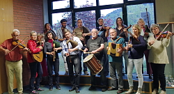 Das Foto zeigt die Teilnehmenden der VHS-Kurse &#34;Musik auf historischen Instrumenten&#34; mit ihren Geigen, Flöten, mit dem Dudelsack und einer Trommel.