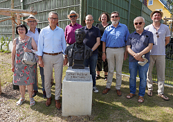 Das Foto zeigt Oberbürgermeister Markus Ibert und Vertreterinnen und Vertreter bei der Einweihung des neuen Spielplatzes in der Louis Pasteur Straße in Lahr. In der Mitte des Bildes steht die Büste des Chemikers Louis Pasteur. 