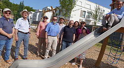 Das Foto zeigt die neuen Spielgeräte wie eine Rutsche, ein Klettergerüst und einer Schaukel auf dem neuen Spielplatz in der Louis Pasteur Straße in Lahr.&#13;&#10;Auf der Rutsche sitzt Oberbürgermeister Markus Ibert und in der Mitte des Fotos sind Vertreterinnen und Vertreter der Stadtverwaltung und des Gemeinderats zu sehen.