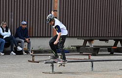 Jugendlicher slidet an einer Rail entlang.