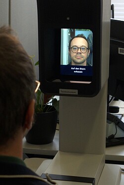 Mann schaut in das Foto-Terminal und macht ein Passfoto.