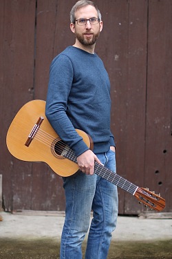 Markus Nierlin posiert mit Gitarre.