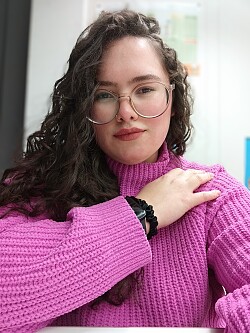 Portrait von Mônica Ribeiro Marques im pinken Pullover.