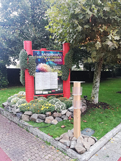 Das Beet mit Chrysanthemenbüschen und -kaskaden präsentiert auf einer Dreieckssäule mit großformatigen Plakaten das Motto „Sagenhaft!“ 