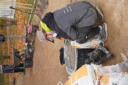 Diese FSJlerin mischt gerade Kalkputz zusammen. Sie trägt dabei eine Atemmaske.