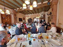 Auf dem Foto sieht man zahlreiche Gäste an gedeckten Frühstückstischen, im Hintergrund spricht Oberbürgermeister Markus Ibert zu ihnen