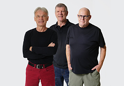 „Grautöne“ treten bei der MuseumsBar auf. Sie posieren zu dritt vor einer weißen Leinwand.