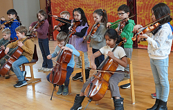 Kinder der Streicherklasse spielen im Orchestersaal der Städtischen Musikschule verschiedene Streichinstrumente wie Violinen und Celli