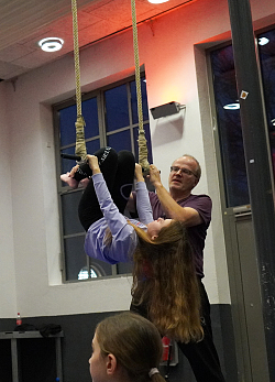 Fritz Kälble vom Zirkus Lahrifahri zeigt einem Mädchen Übungen am Trapez  