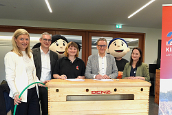 OB Markus Ibert unterzeichnet den Vertrag auf einem Turnkasten. Um ihn stehen die Verantwortlichen des Badischen Turnerbundes und die Maskottchen des Kinderturnfestes. 