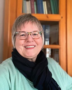 Porträt einer Frau vor einem Bücherregal