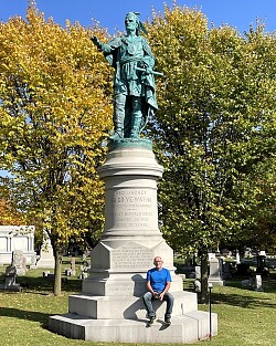 Das Foto zeigt Dr. Karl Schäfer sietzend wie einst Karl May am Red Jacket Denkmal in Buffalo. 