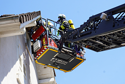 Feuerwehrmann mit Atemschutz auf Drehleiter 