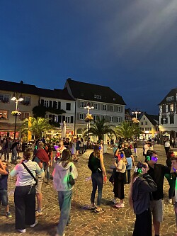 Tanzende Menschen mit leuchtenden Kopfhörern