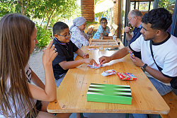 Das Foto zeigt Personen beim letztjährigen Café international. Sie spielen Gesellschaftsspiele.
