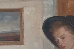 Zu sehen ist eine junge Frau mit Hut. Sie sitzt an einem Tisch und liest in einem dünnen Buch. Vor ihr auf dem Tisch steht ein kleiner Krug. Im Hintergrund ist ein Zimmer zu sehen mit Kommode, Bild und Pflanze 