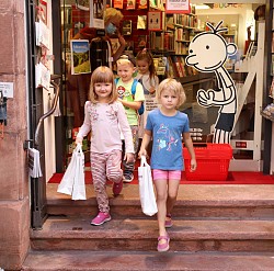 Kinder gehen bepackt mit Tüten die Treppen der Buchhandlung Schwab hinuntern. 