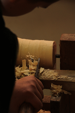 Zu sehen ist ein Kind, das schnitzt.