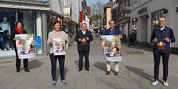 Gruppenbild vor der Marktstraße, die Personen halten das Plakat &#34;Willkommen zurück!&#34; in der Hand und stehen von links Friederike Ohnemus (Leitung Abteilung Ratsarbeit, Marketing und Internationales), Martina Mundinger (Leiterin Stadtmarketing), Andres Feißt (DEHOGA Lahr), Oberbürgermeister Markus Ibert und Michael Schmiederer (Vorsitzender Werbegemeinschaft Lahr)