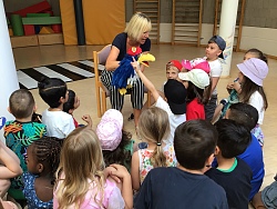 Der Rabe ADACUS sitzt mit den Kindern im Kreis und bespricht wichtige Regeln im Verkehr. Die Kinder hören begeistert zu und machen eifrig mit.
