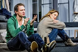 Ralf Bauer und Ann-Cathrin Sudhoff sitzen nebeneinander auf dem Boden.