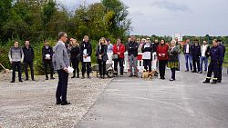 Oberbürger Meister Ibert mit Mikrofon vor einer Gruppe von Zuhörenden, die in einer Reihe stehen