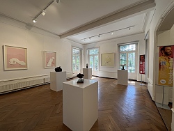 Kleine Skulpturen auf weißen Sockeln im Ausstellungsraum der Villa Jammm.