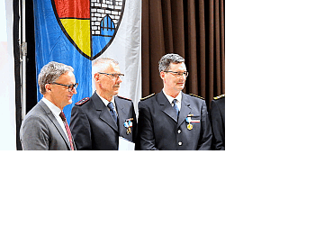 Die Geehrten stehen mit OB Markus Ibert in Ausgehuniform auf der Bühne. 