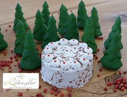 Süßes Gebäck in Form einer Torte und mehrere Tannenbäumchen