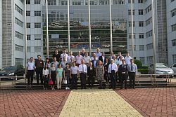 Die Stadt Lahr und die Freiburg Wirtschafr Messe und Touristik GmbH sind Mitglieder der ISA. Das Bild zeigt die Delegation und die ISA-Mitglieder bei einem Gruppenbild bei dem Unternehmen Vanward. Die Fassade hinter der Gruppe ist verspiegelt und modern. 