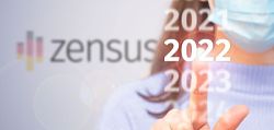 Eine Frau tippt mit dem Zeigefinger gegen die Scheibe. Der Finger tippt auf die Aufschrift &#34;2022&#34;. Darüber steht in verschwommener Schrift &#34;2021&#34; und drunter &#34;2023&#34;. Im Hintergrund steht in verschwommener Schrift &#34;Zensus&#34;.