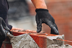 Mauerbau mit Kelle und Mörtel. Quelle: Irene Miller/shutterstock.com