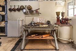 Verschiedene Utensilien wie Nudelhölzer und Siebe, die man zum Backen benötigt, sind auf einem kleinen Tisch in der Backstube platziert.